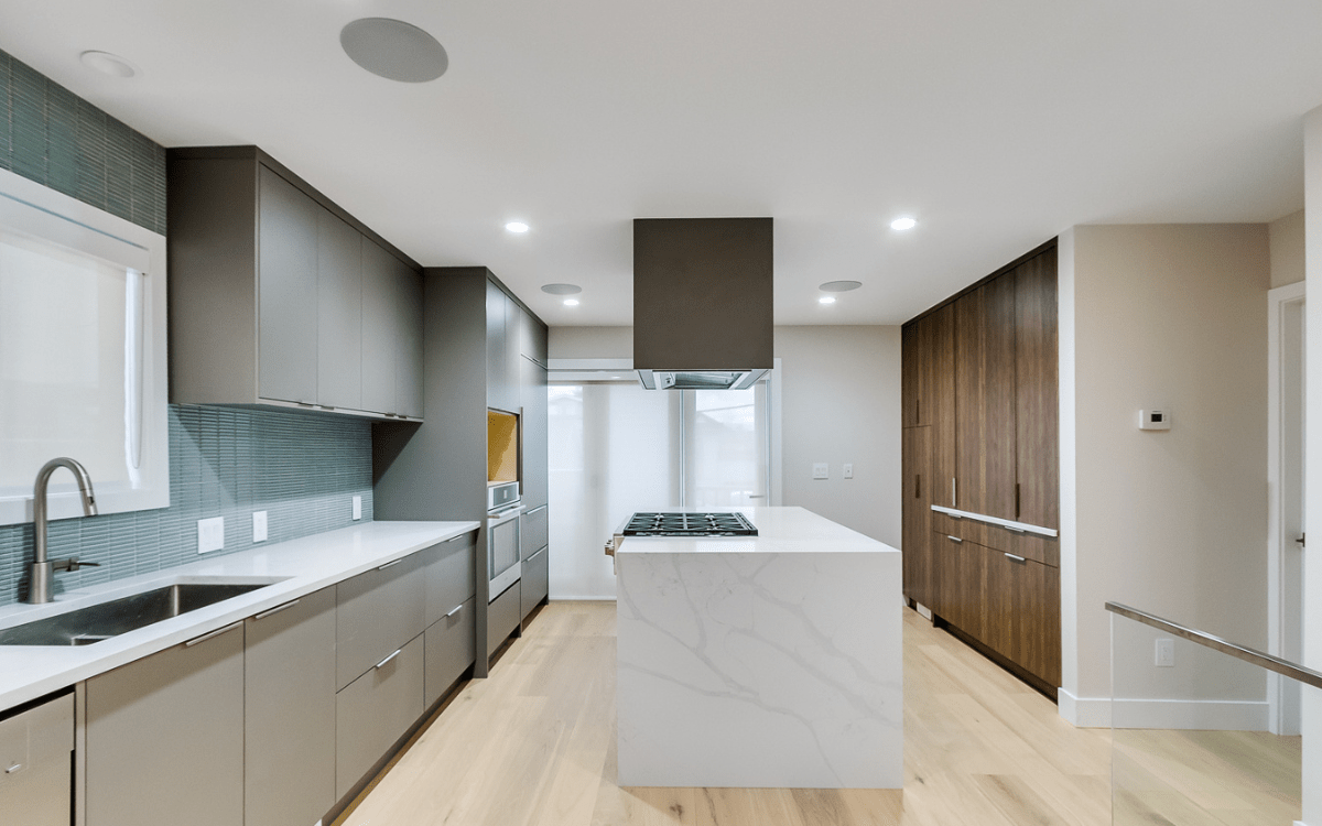 Kitchen renovation with marble countertops and elegant lighting.