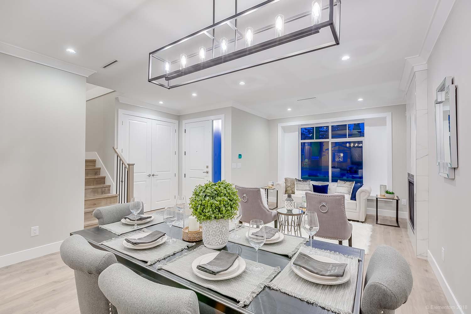 Dining area with glass table, upholstered chairs and modern lighting in a Vancouver home