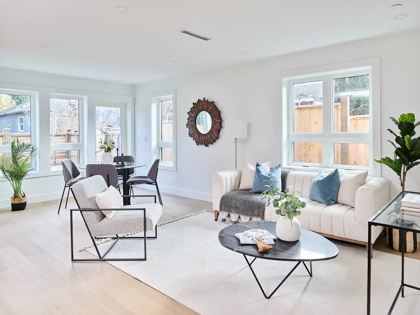 Vancouver living room with cream sofa, blue accent pillows, and round wood mirror