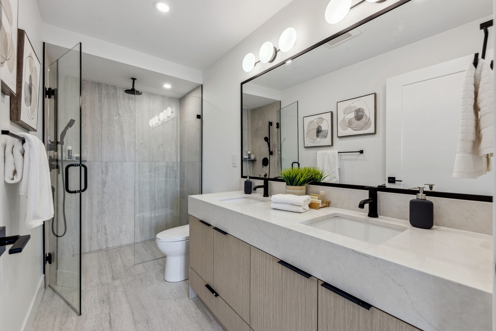 Vancouver bathroom with double vanity, glass shower, and stone tile
