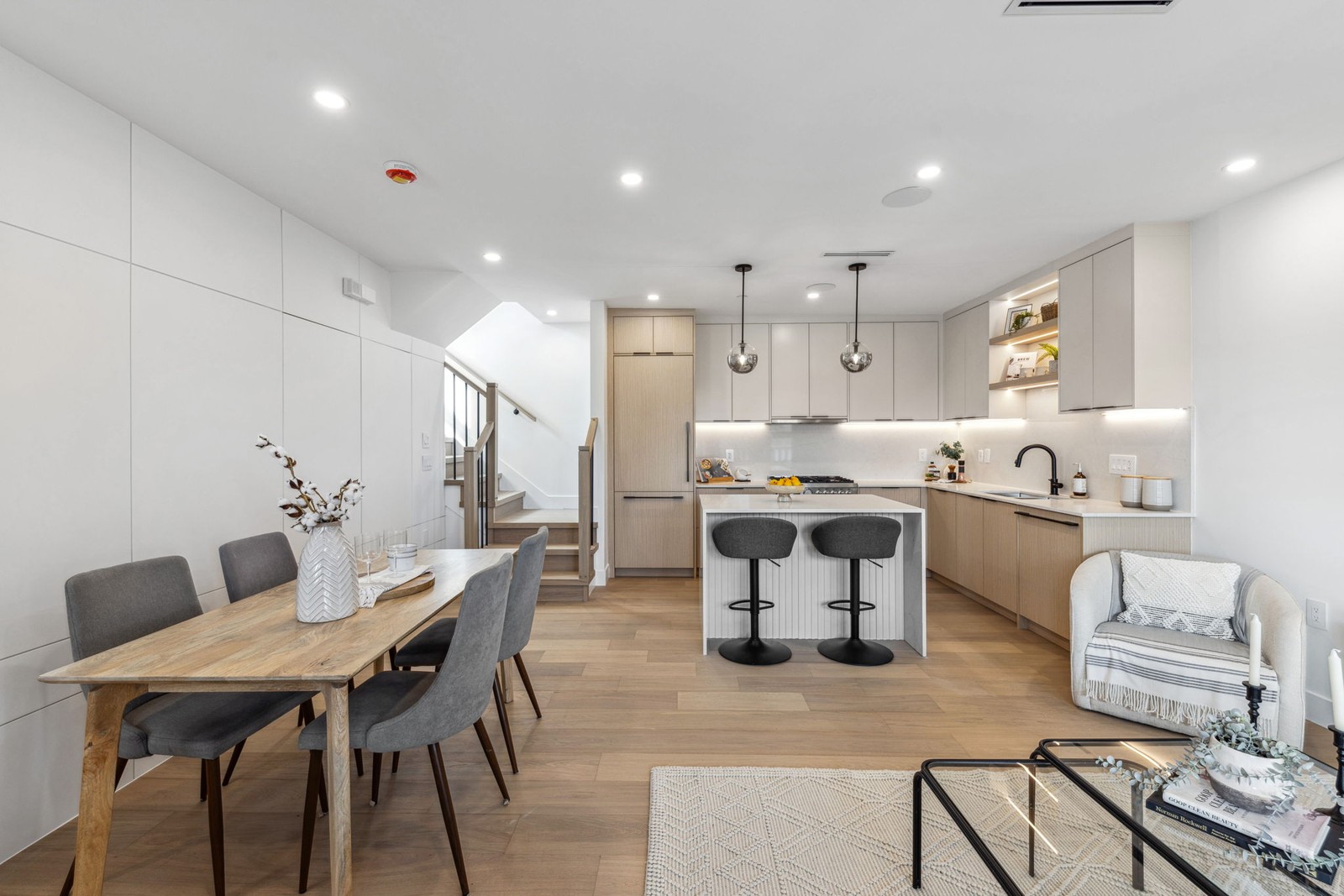 Vancouver kitchen island with bar stools next to dining table and staircase