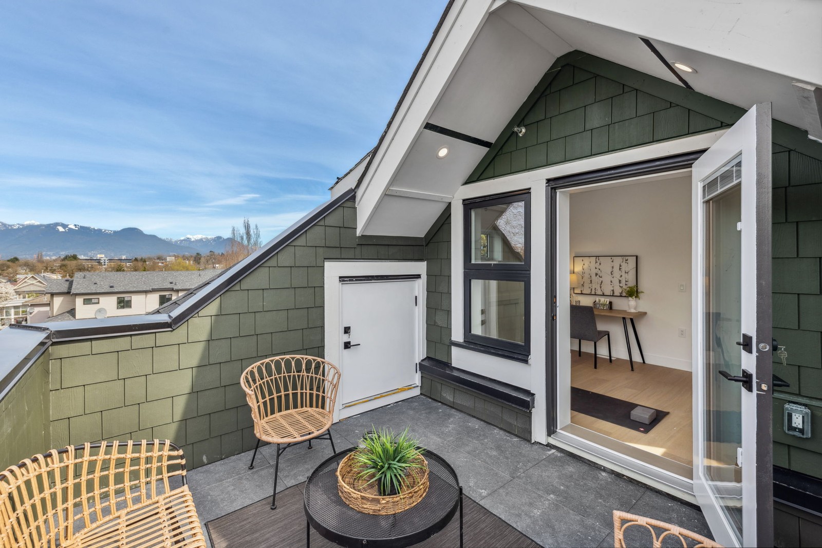 Vancouver rooftop deck opening to loft office with mountain and city view
