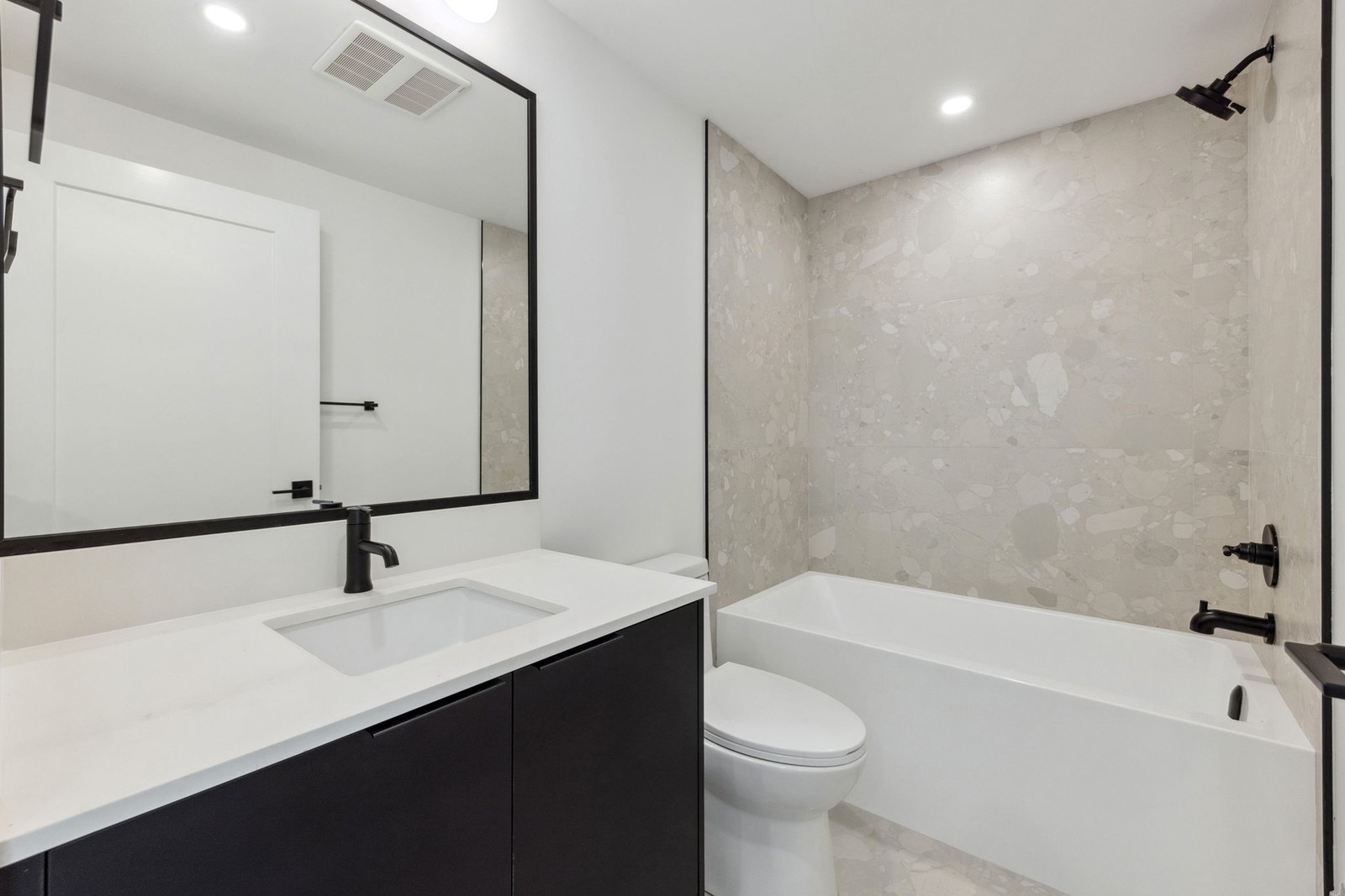 Vancouver bathroom with soaker tub, terrazzo tile, and dark vanity