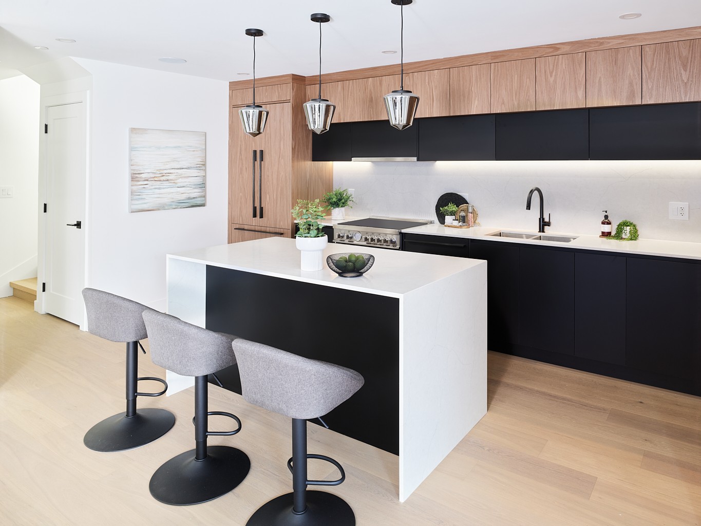 Vancouver kitchen with matte black cabinetry, glass pendant lights, and quartz waterfall island