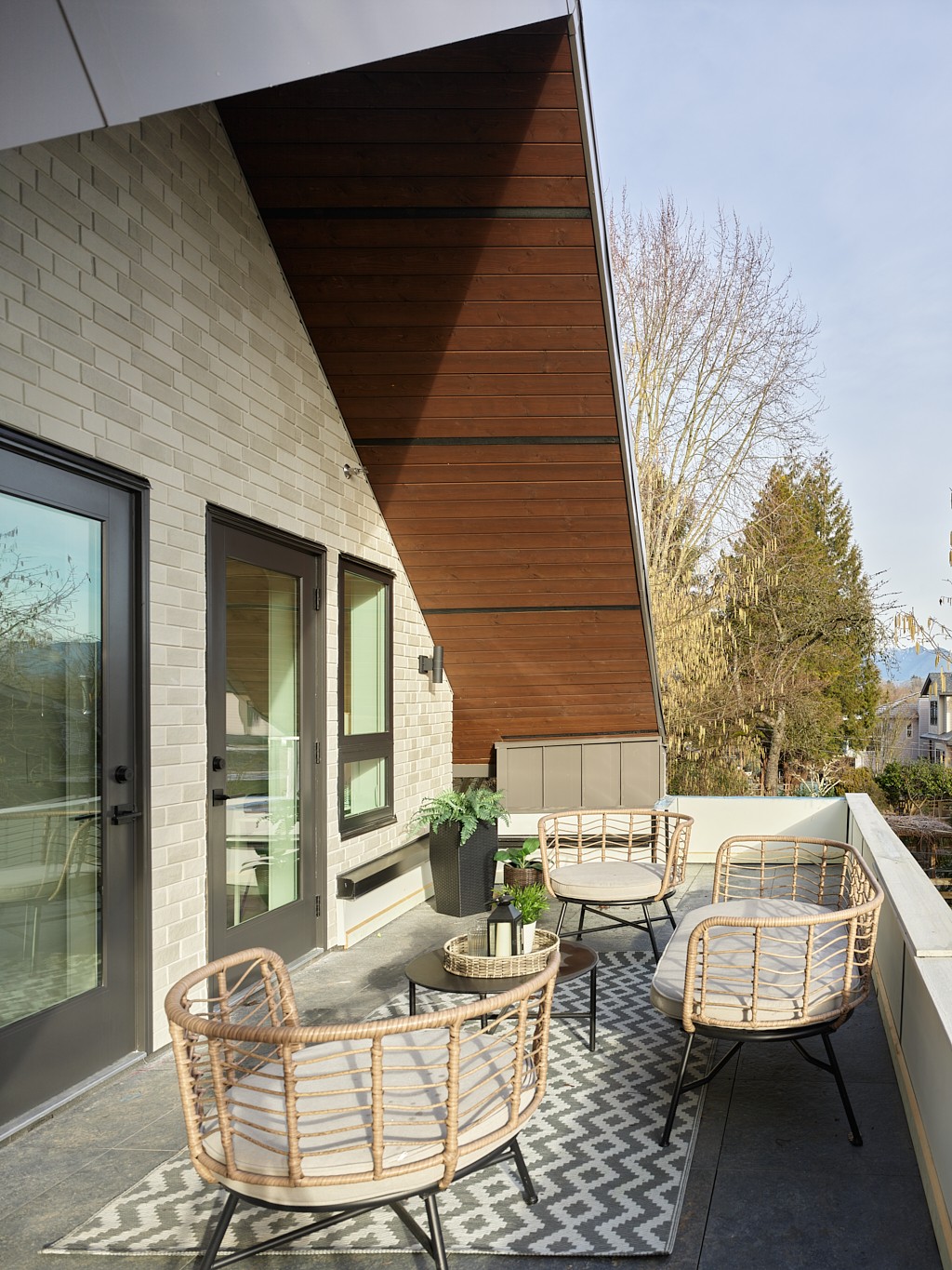 Vancouver rooftop deck with woven rattan chairs, patterned outdoor rug, and cedar accent ceiling Vancouver rooftop deck with woven rattan chairs, patterned outdoor rug, and cedar accent ceiling
