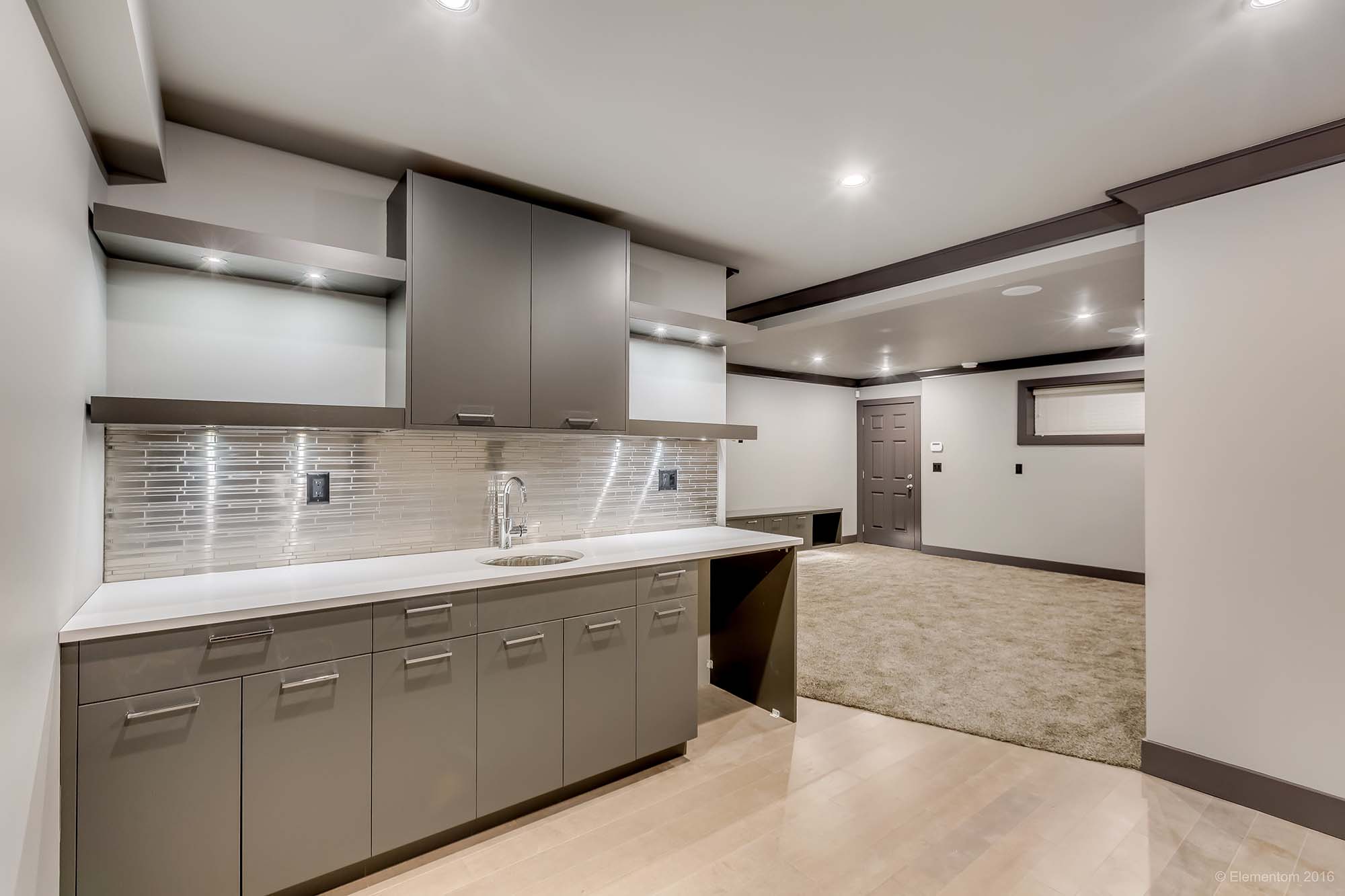 Modern Greater Vancouver custom home kitchen with gray cabinetry, stone counters, recessed lighting, and bright contemporary finishes