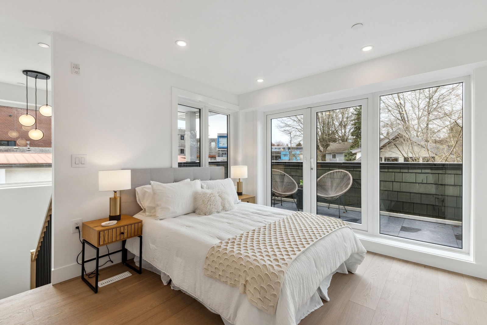Vancouver primary bedroom with glass balcony doors and pendant lighting