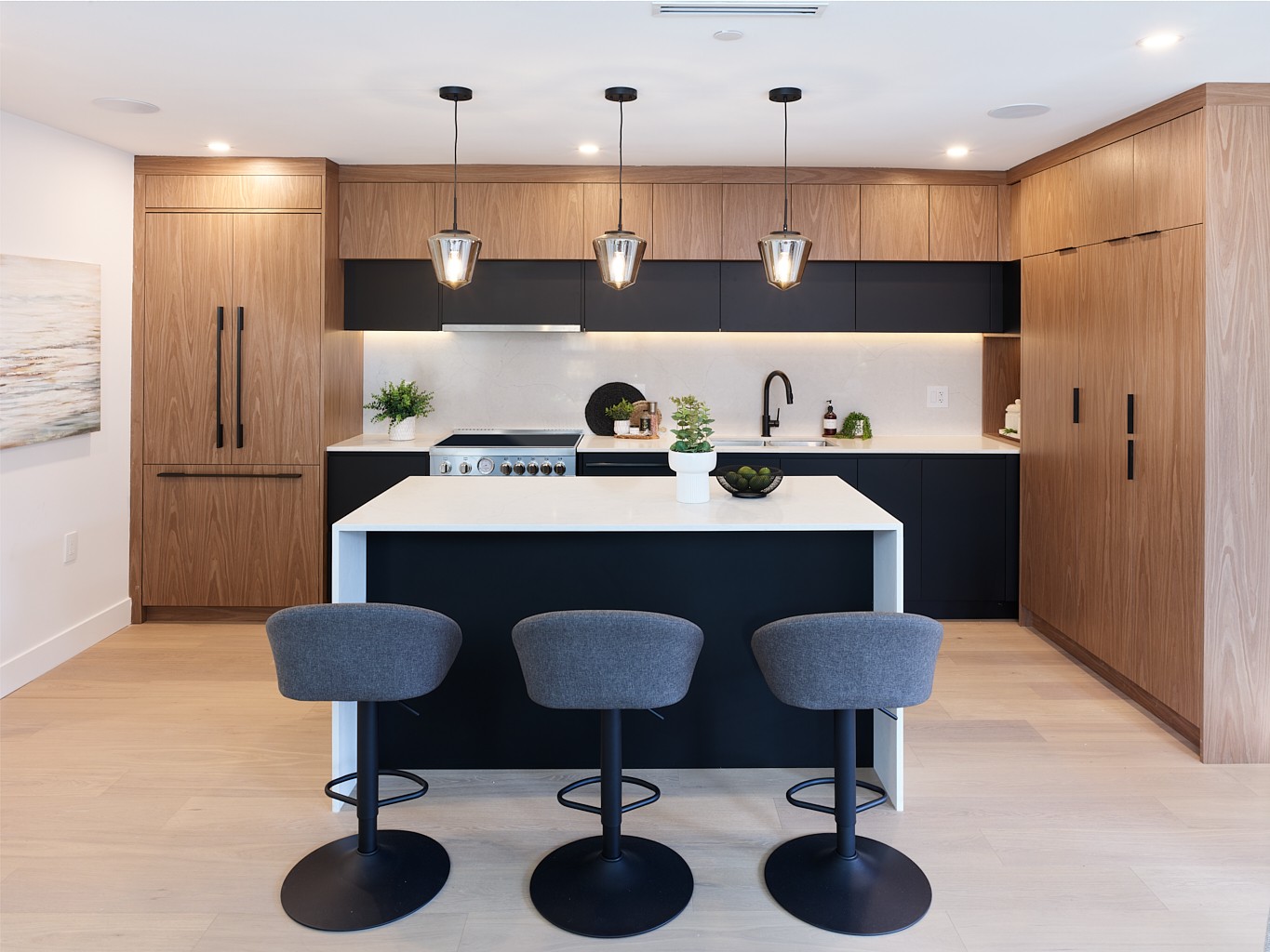Vancouver kitchen with waterfall quartz island, walnut cabinetry, and black bar stools